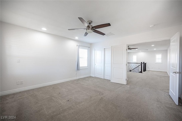 unfurnished bedroom with light carpet and ceiling fan