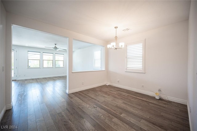 spare room featuring ceiling fan with notable chandelier and dark hardwood / wood-style floors