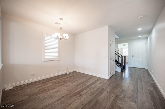 unfurnished room with dark hardwood / wood-style floors and a notable chandelier