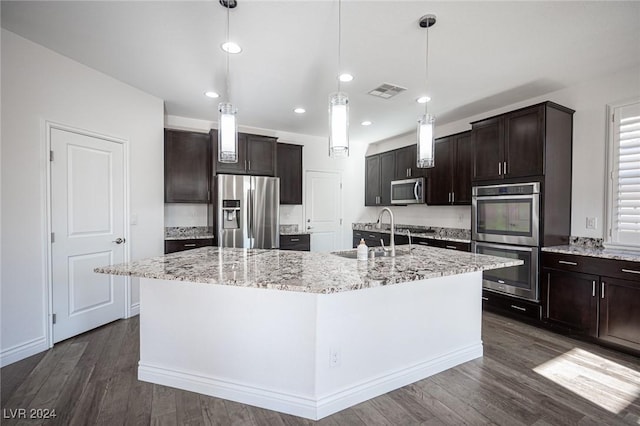 kitchen featuring sink, dark wood-type flooring, decorative light fixtures, a kitchen island with sink, and appliances with stainless steel finishes