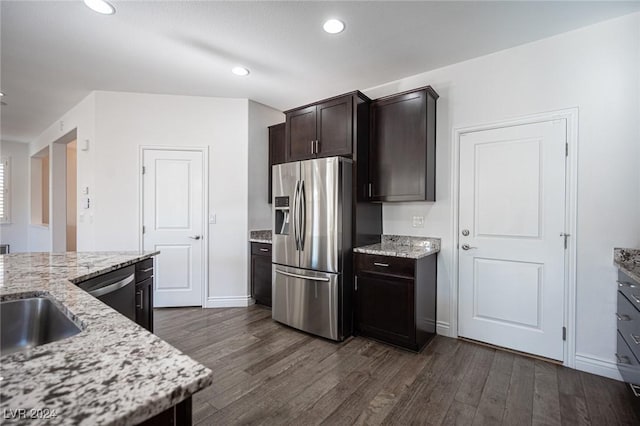 kitchen featuring appliances with stainless steel finishes, dark hardwood / wood-style flooring, light stone counters, and dark brown cabinets