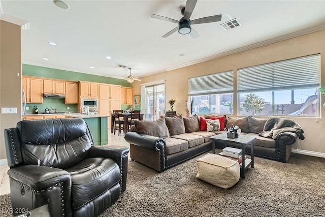 living room featuring carpet, ceiling fan, and crown molding