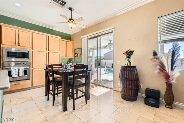 tiled dining area featuring ceiling fan and crown molding