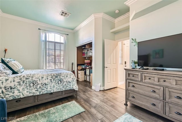 bedroom with hardwood / wood-style flooring, a closet, and ornamental molding