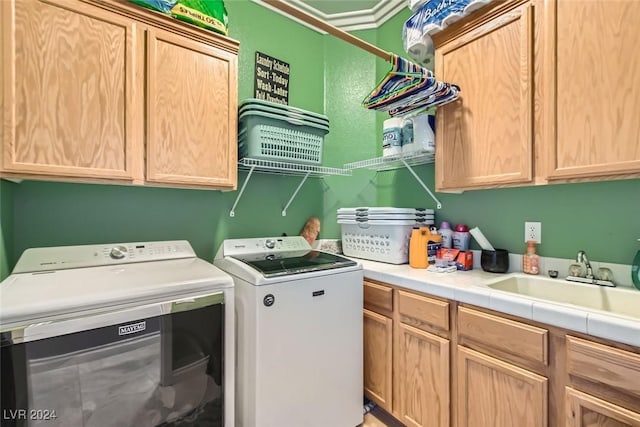 laundry area featuring washer and dryer, cabinets, and sink