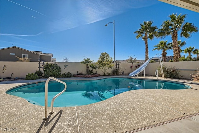 view of swimming pool with a patio area and a water slide