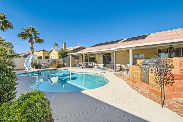 view of swimming pool with a patio, ceiling fan, and a water slide