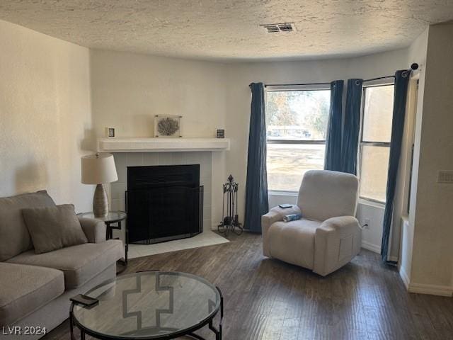 living room featuring hardwood / wood-style flooring, a fireplace, and a textured ceiling