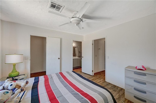 bedroom with ceiling fan, ensuite bathroom, and light hardwood / wood-style flooring