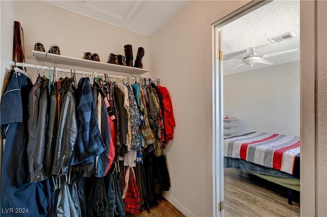 spacious closet featuring ceiling fan and wood-type flooring