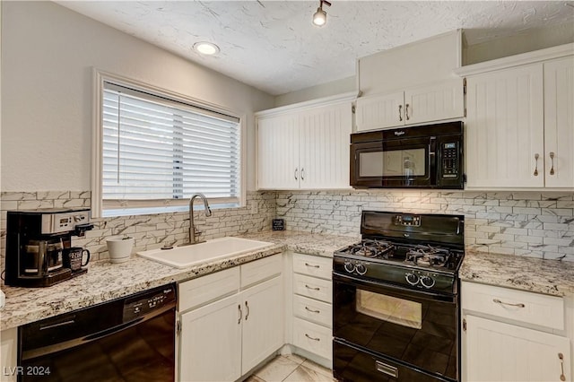 kitchen with decorative backsplash, a textured ceiling, black appliances, white cabinets, and sink