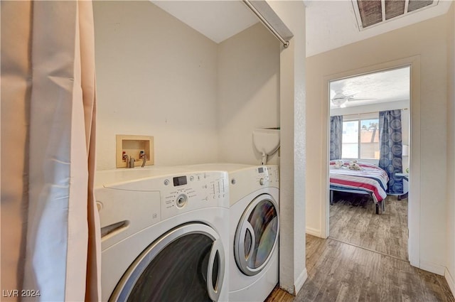 clothes washing area with washing machine and dryer and hardwood / wood-style floors