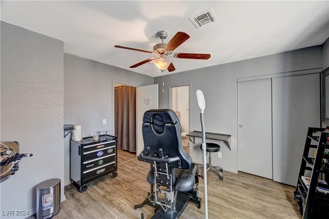 workout area featuring light wood-type flooring and ceiling fan