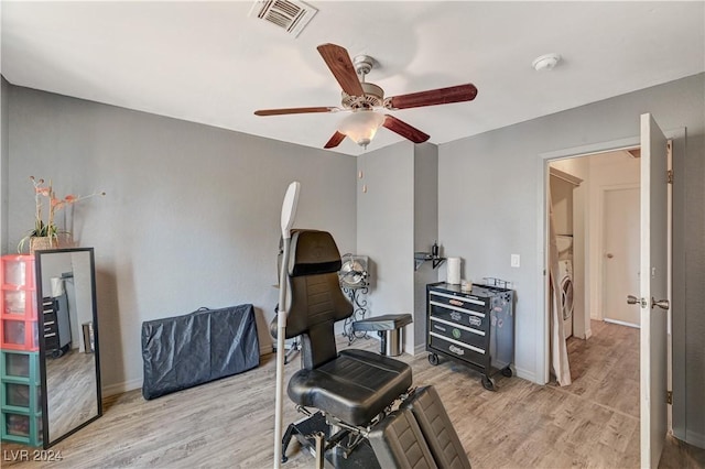 living area featuring ceiling fan, light wood-type flooring, and washer / dryer