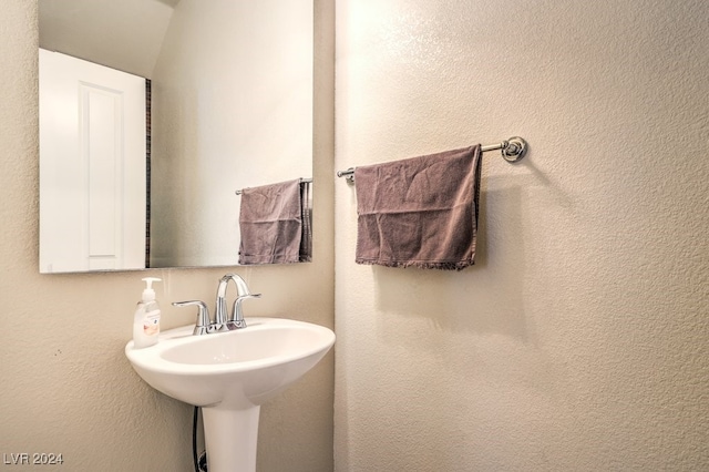 bathroom featuring vaulted ceiling and sink