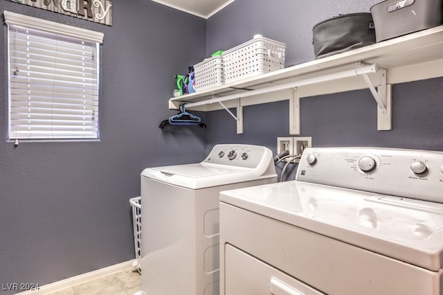 clothes washing area with washing machine and dryer and tile patterned floors