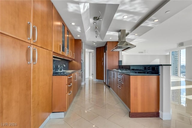 kitchen with stainless steel gas stovetop, exhaust hood, dark stone counters, light tile patterned floors, and tasteful backsplash