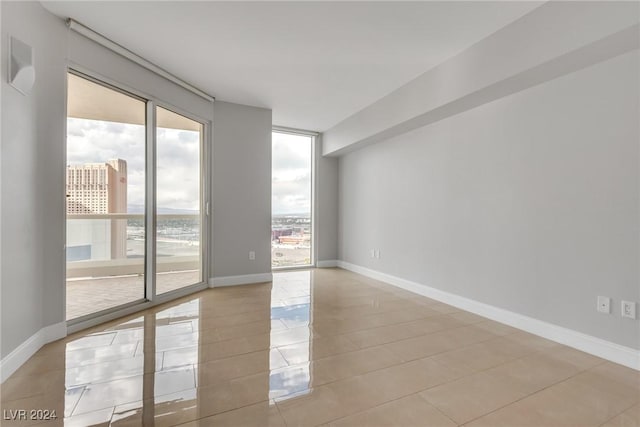 empty room with a water view and light tile patterned flooring