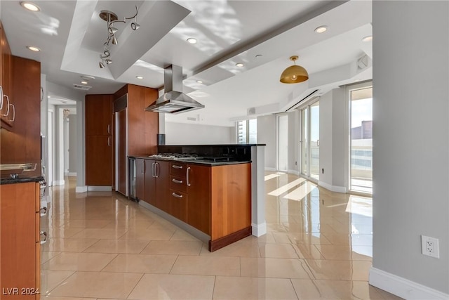 kitchen with wall chimney exhaust hood, light tile patterned floors, and appliances with stainless steel finishes