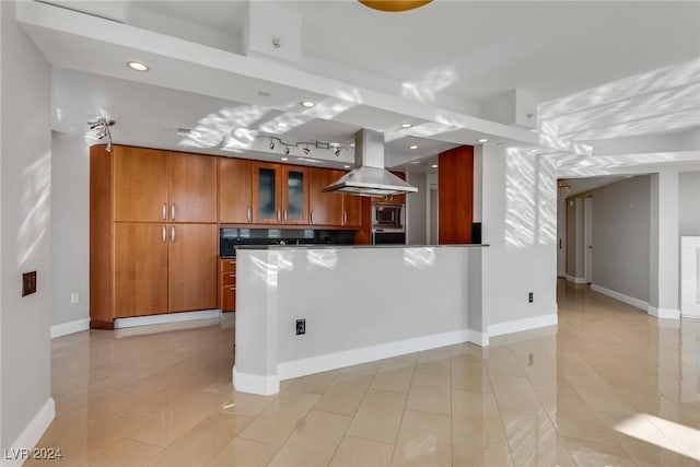 kitchen with island exhaust hood and appliances with stainless steel finishes