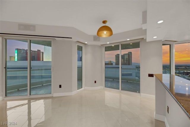 spare room featuring a healthy amount of sunlight and light tile patterned floors