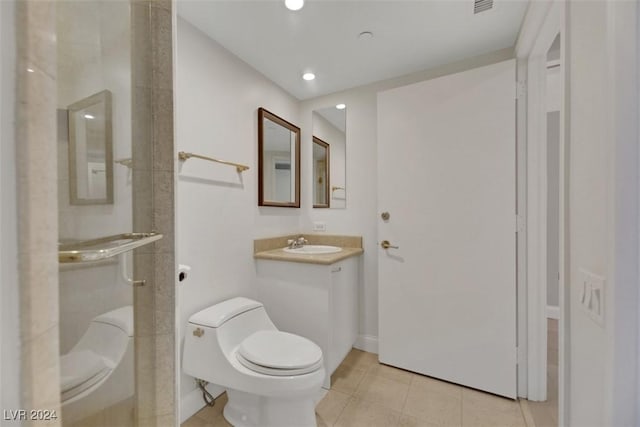 bathroom featuring tile patterned floors, vanity, toilet, and a shower with door