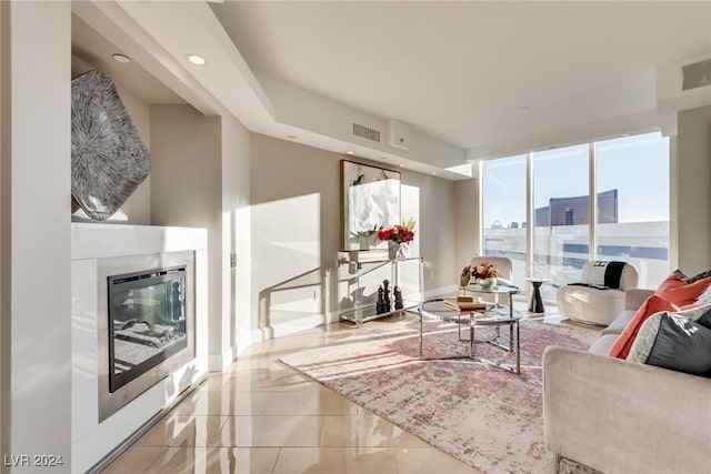 living area with recessed lighting, visible vents, baseboards, tile patterned floors, and a glass covered fireplace