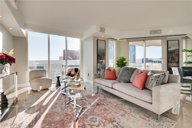 living area featuring a city view, plenty of natural light, visible vents, and baseboards