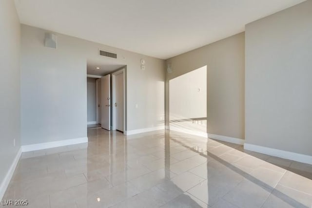 unfurnished room featuring light tile patterned floors, baseboards, and visible vents