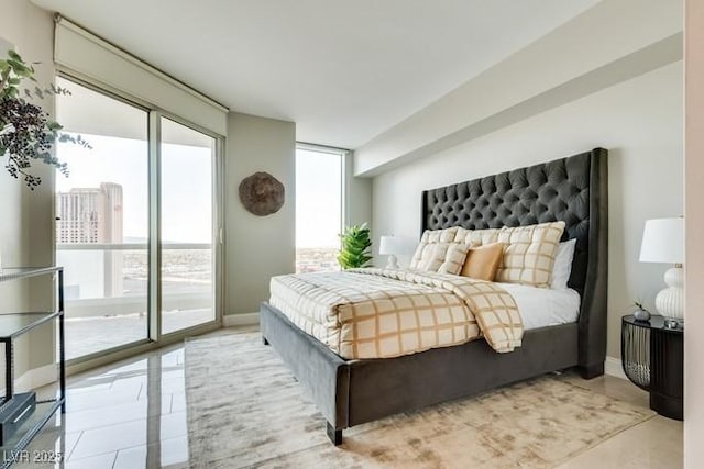 bedroom with access to exterior, floor to ceiling windows, baseboards, and light tile patterned floors