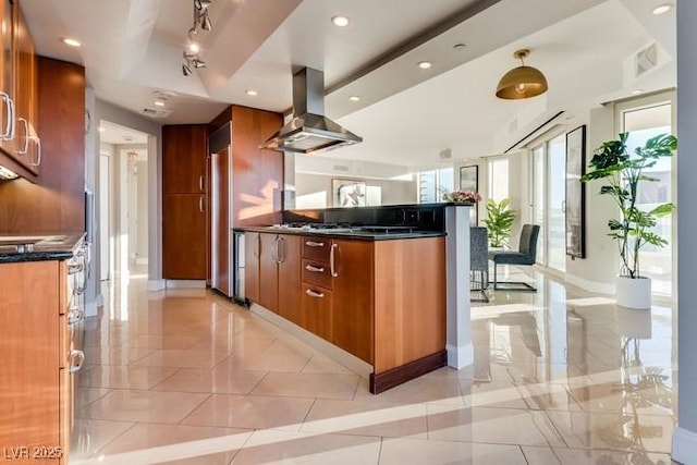 kitchen featuring modern cabinets, brown cabinets, a peninsula, marble finish floor, and island exhaust hood