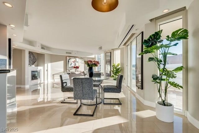 dining room featuring recessed lighting, a fireplace, and baseboards