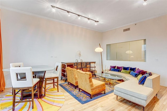 living room with crown molding, rail lighting, and light wood-type flooring