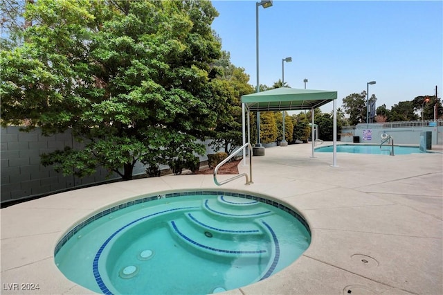 view of pool featuring a gazebo, a patio area, and a hot tub