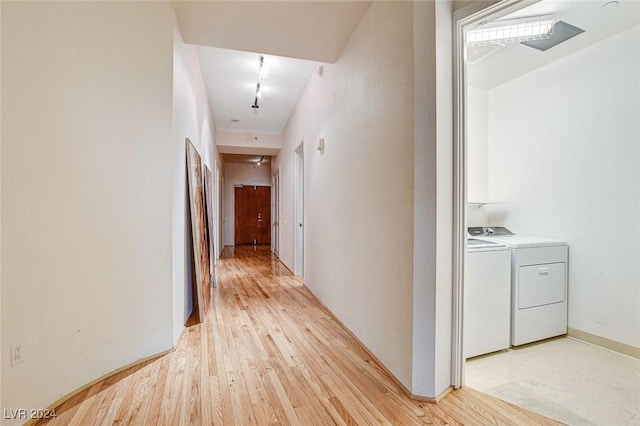 hall with light wood-type flooring and washing machine and dryer