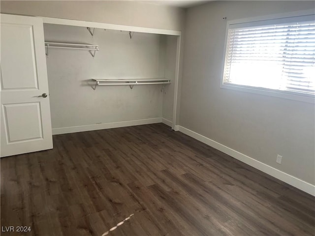 unfurnished bedroom featuring dark hardwood / wood-style floors and a closet