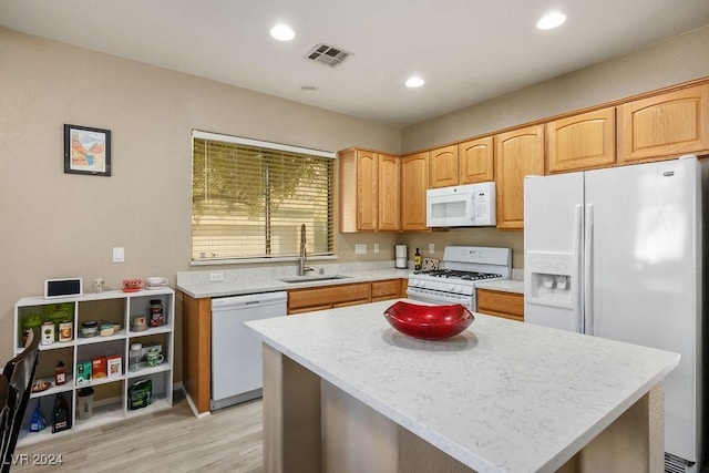 kitchen with a center island, white appliances, light hardwood / wood-style floors, and sink