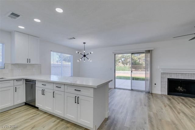 kitchen with kitchen peninsula, white cabinets, hanging light fixtures, and dishwasher