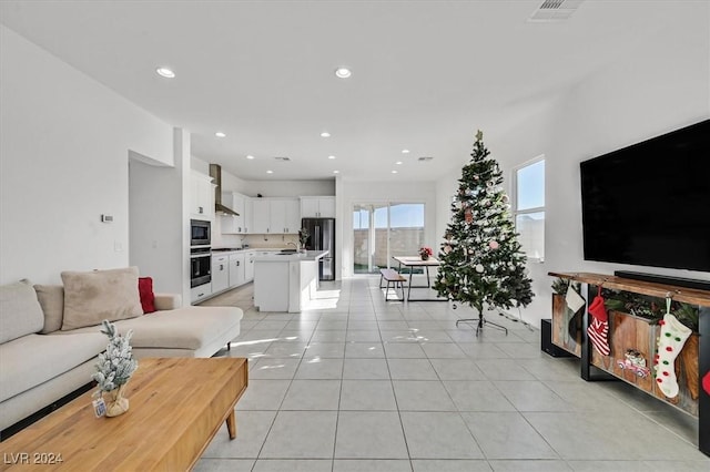 living room featuring sink and light tile patterned flooring