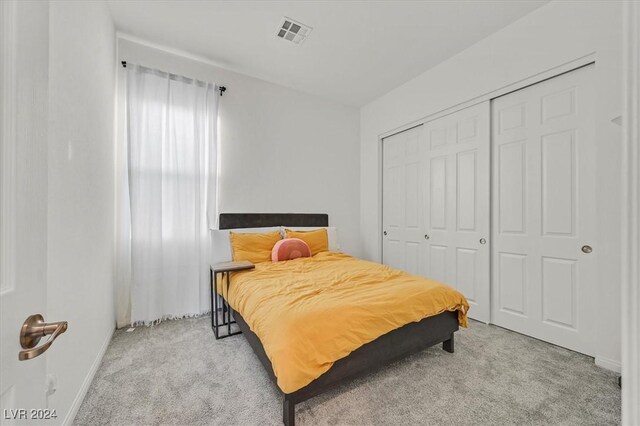 bedroom with light colored carpet and a closet