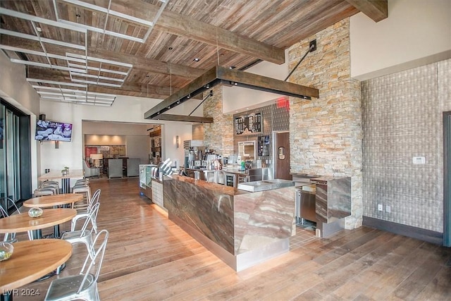 kitchen featuring beam ceiling, hardwood / wood-style floors, high vaulted ceiling, and wood ceiling