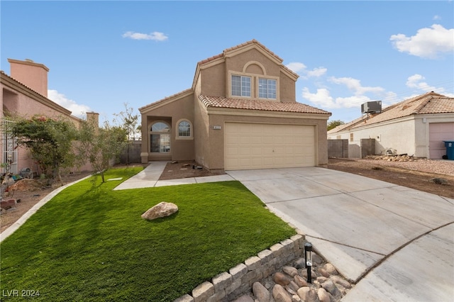 mediterranean / spanish-style house with a garage, a front yard, and central AC