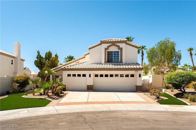 mediterranean / spanish-style house featuring a front yard and a garage