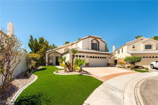 mediterranean / spanish home featuring a front yard and a garage