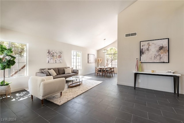 tiled living room featuring high vaulted ceiling and an inviting chandelier