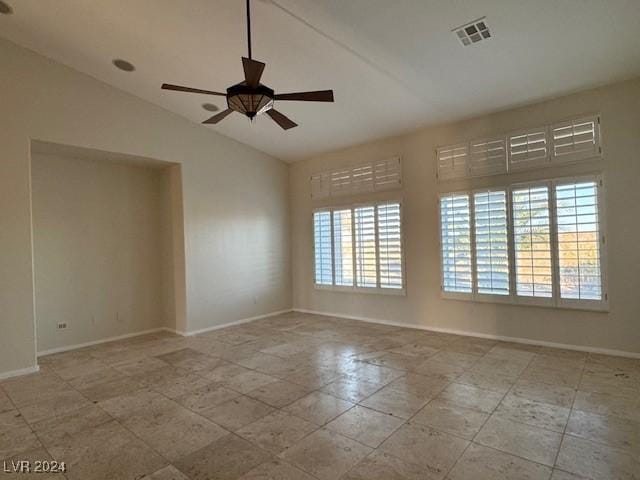 empty room with vaulted ceiling, plenty of natural light, and ceiling fan