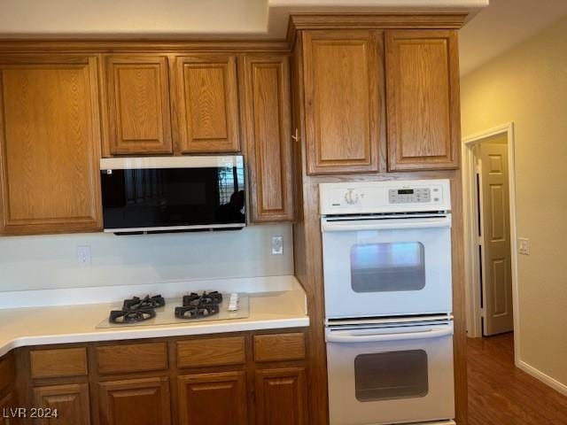 kitchen featuring dark hardwood / wood-style flooring and white appliances