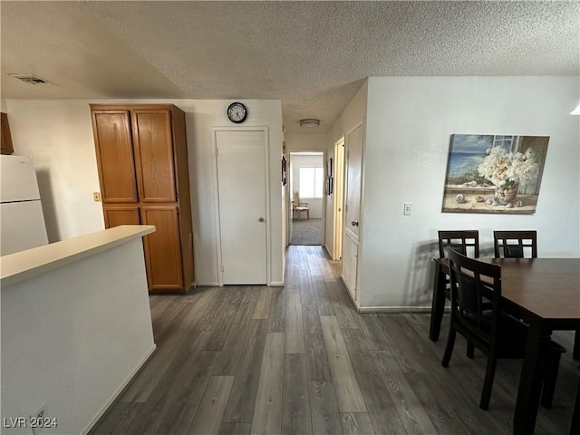 dining area featuring dark hardwood / wood-style flooring and a textured ceiling