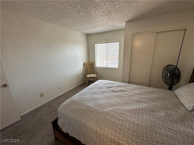 carpeted bedroom with a closet and a textured ceiling