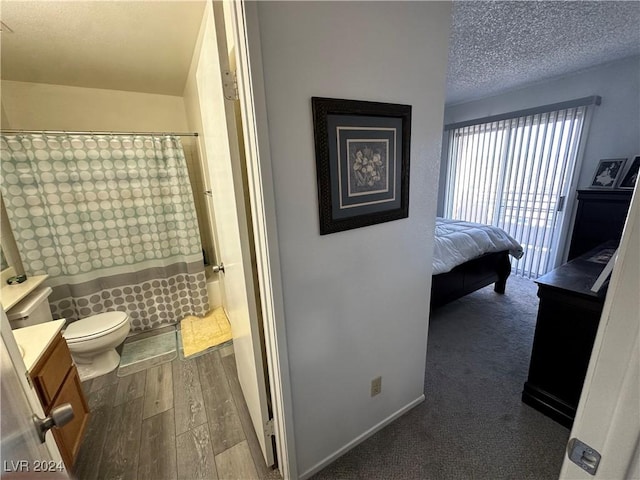 bathroom with hardwood / wood-style floors, vanity, toilet, and a shower with curtain